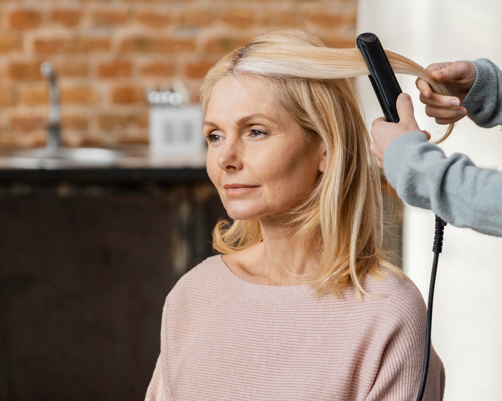 Woman blow-drying fine hair for volume